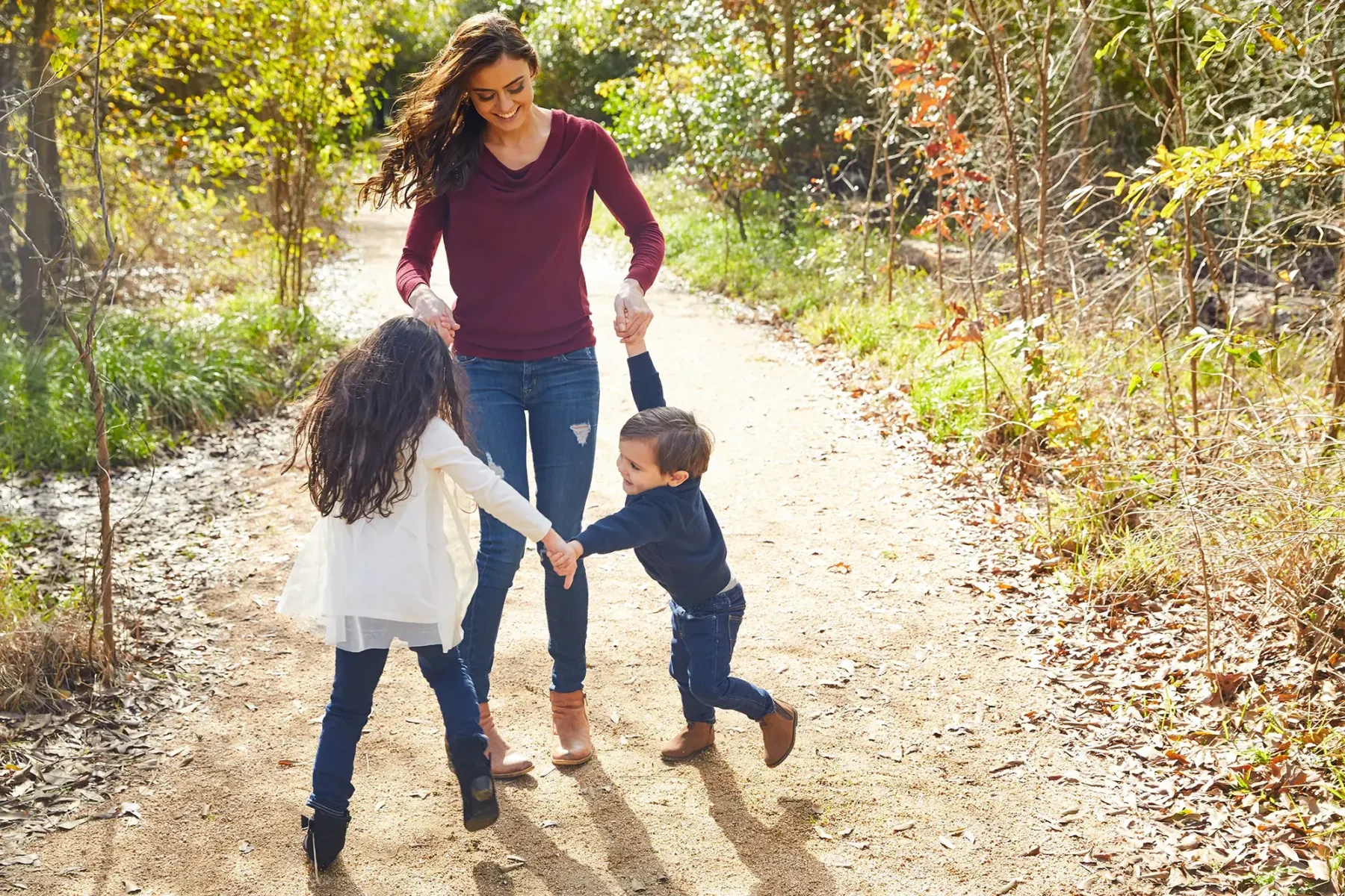 Mother and children dancing on a nature trail