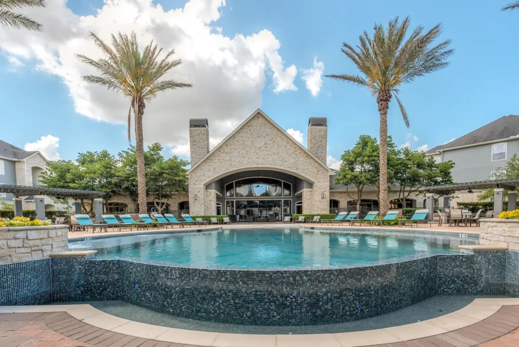 Resort-inspired pool with lounge chairs at Deseo at Grand Mission apartments in Richmond, TX